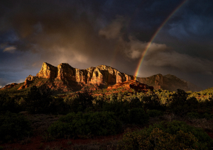 Пейзаж с горами и радугой на закате.